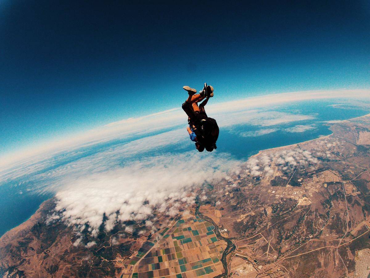 man jumping out of plan above the horizon