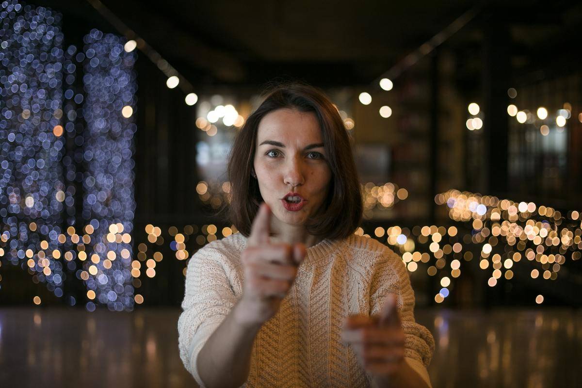 woman points the finger in front of lights