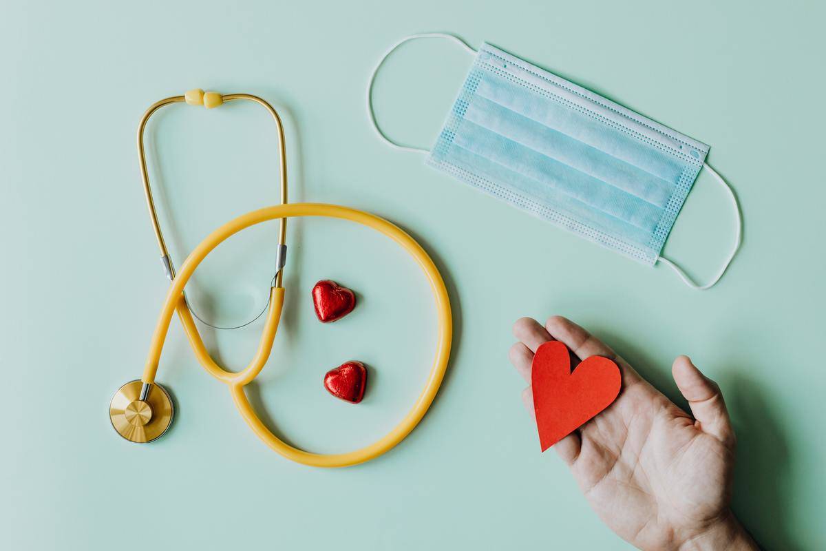 A stethoscope, mask, and heart-shaped objects spread out.