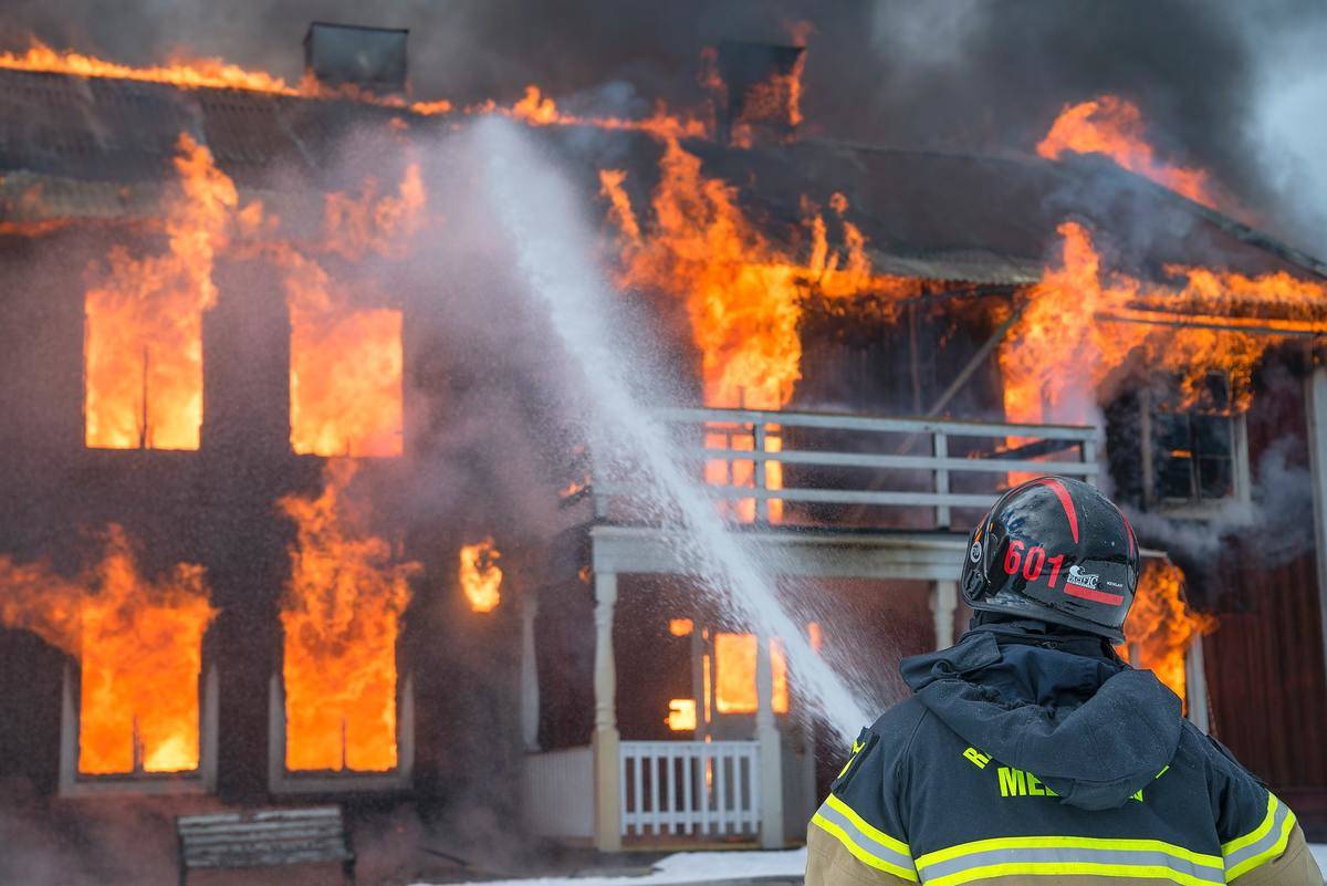 A firefighter putting out a house fire.