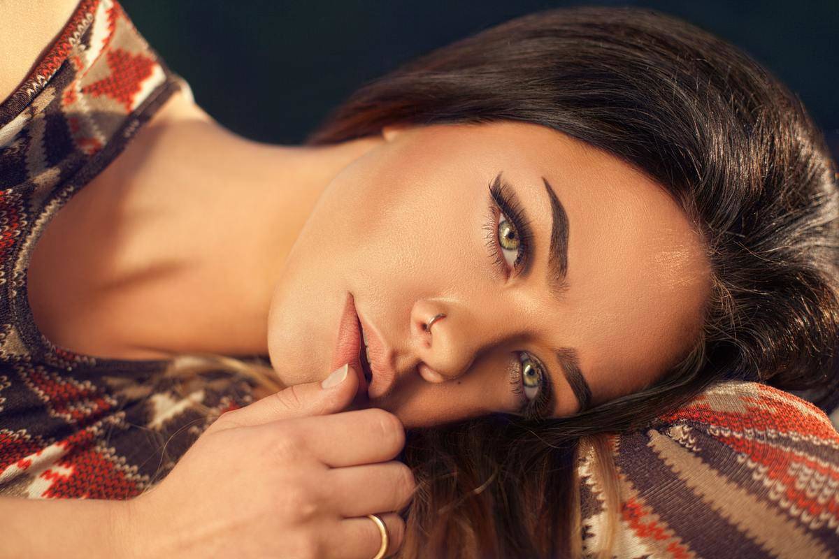 A woman laying on her side looking towards the camera.