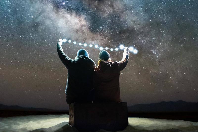 back-view-of-a-couple-holding-light-at-nigh