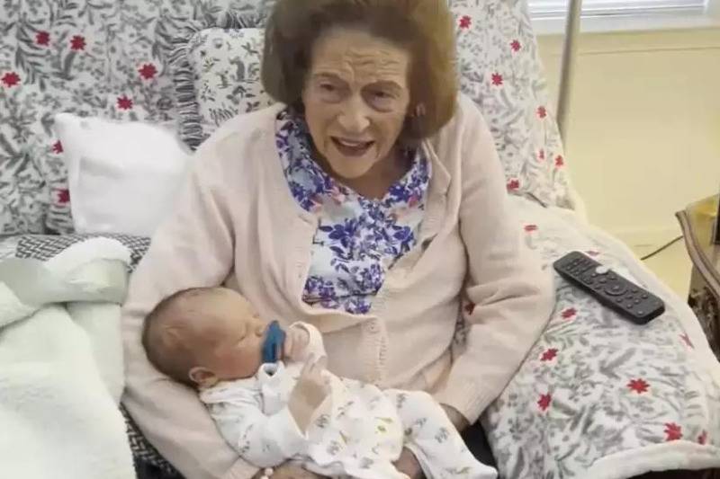 grandma holding baby in bed