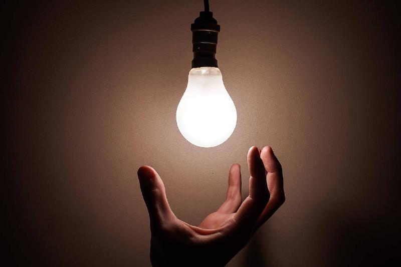 hand reaching for hanging lightbulb
