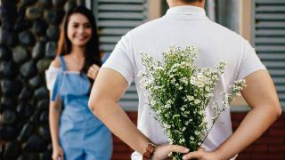 an-holding-baby-s-breath-flower-in-front-of-woman-standing-near-marble-wall-