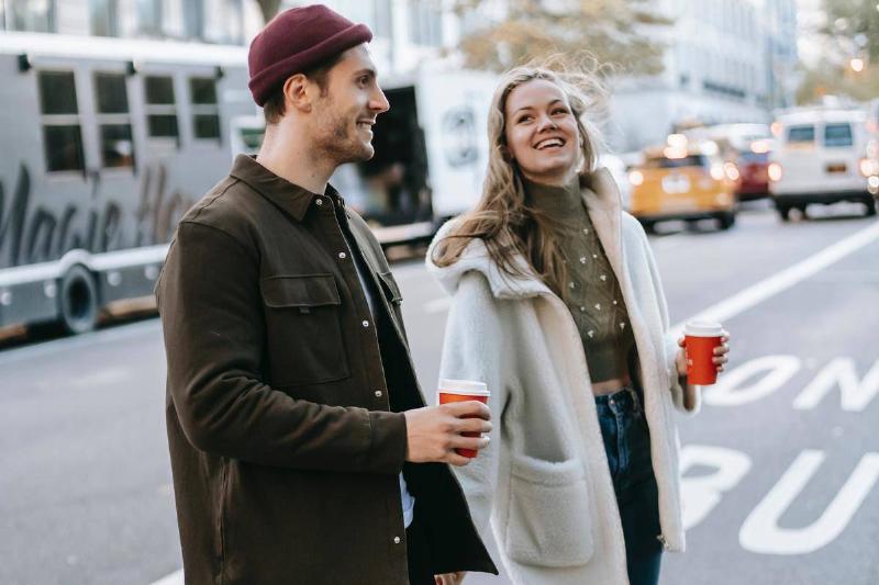 couple-walking-on-street-with-coffee-cups