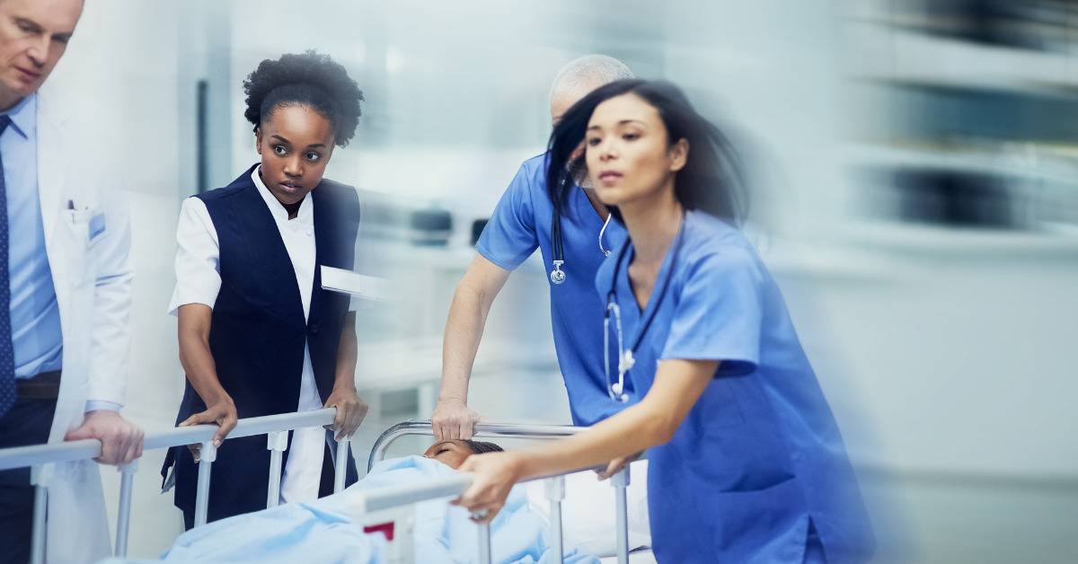 ER scene with doctors rushing to wheel patient on bed