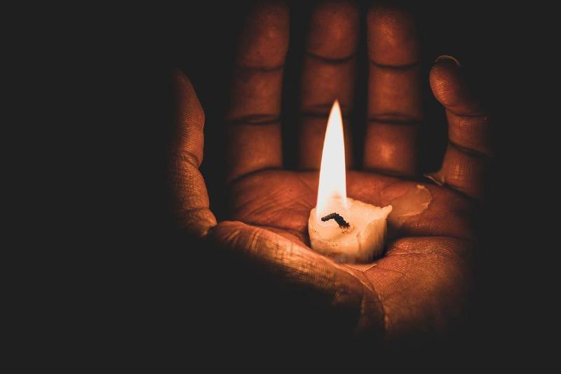 Hand holding burning flame