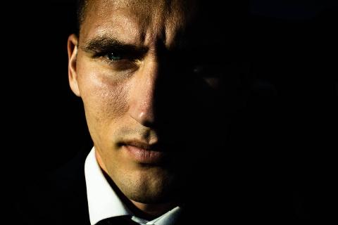 Man In suit Squinting on black background
