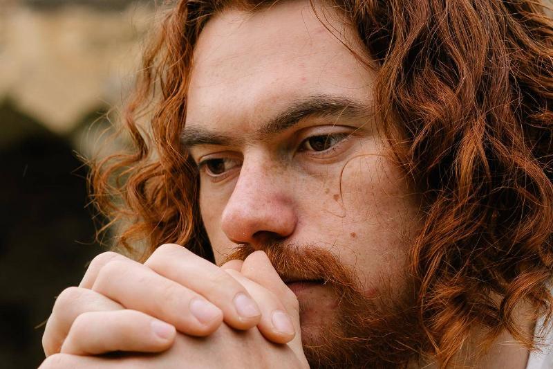 bearded-redheaded-man-praying-with-his-hands-clasped-