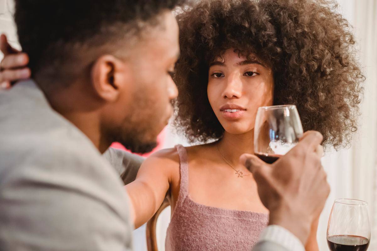 sensual-african-american-woman-looking-at-boyfriend-while they drink wine