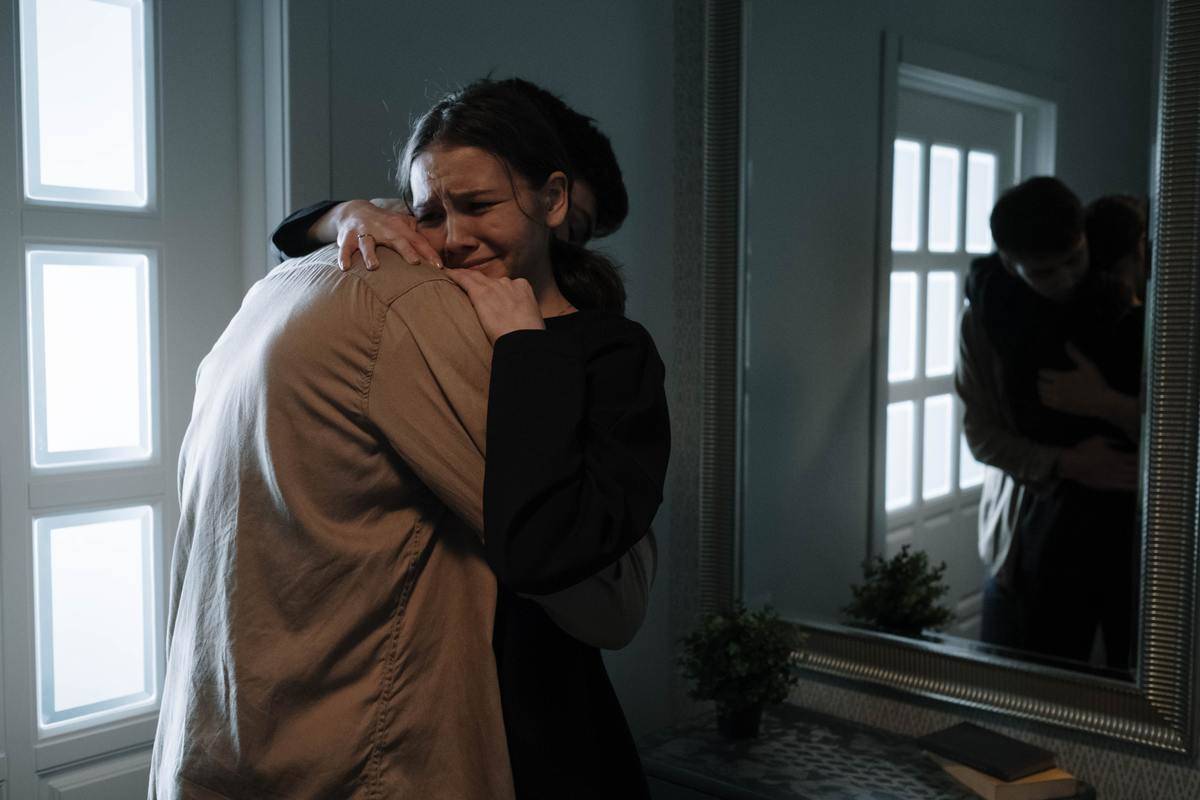 an-emotional-woman-crying-while-hugging-another-person