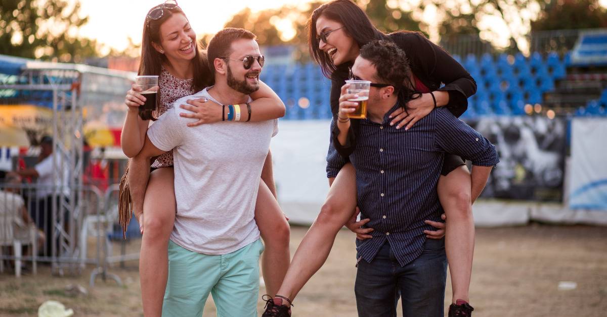 two woman piggy back men beside each other