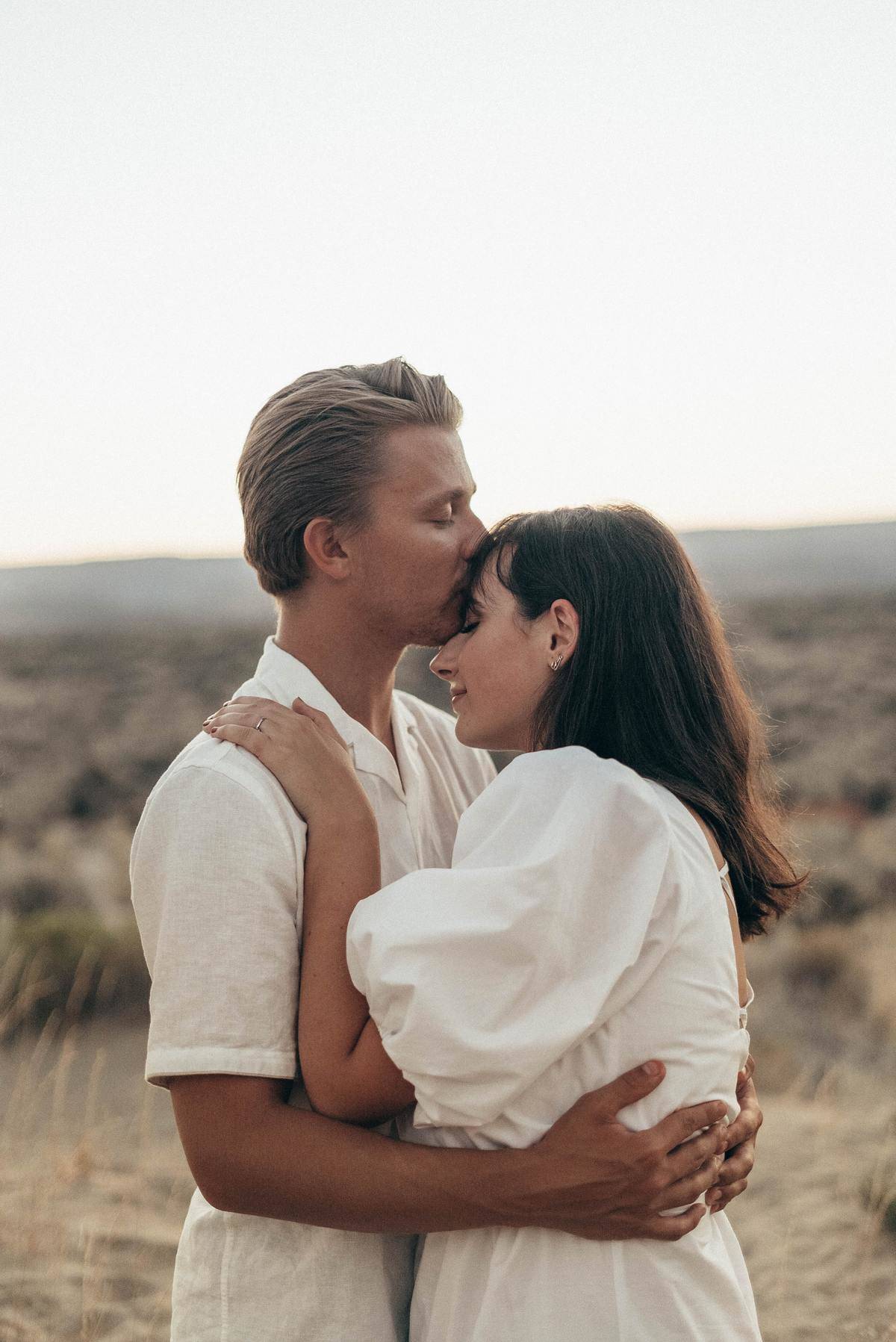 romantic-couple-with-closed-eyes-embracing-in-field