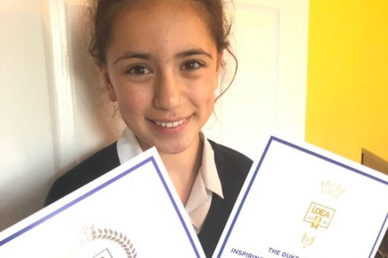 girl holding certificates and smiling