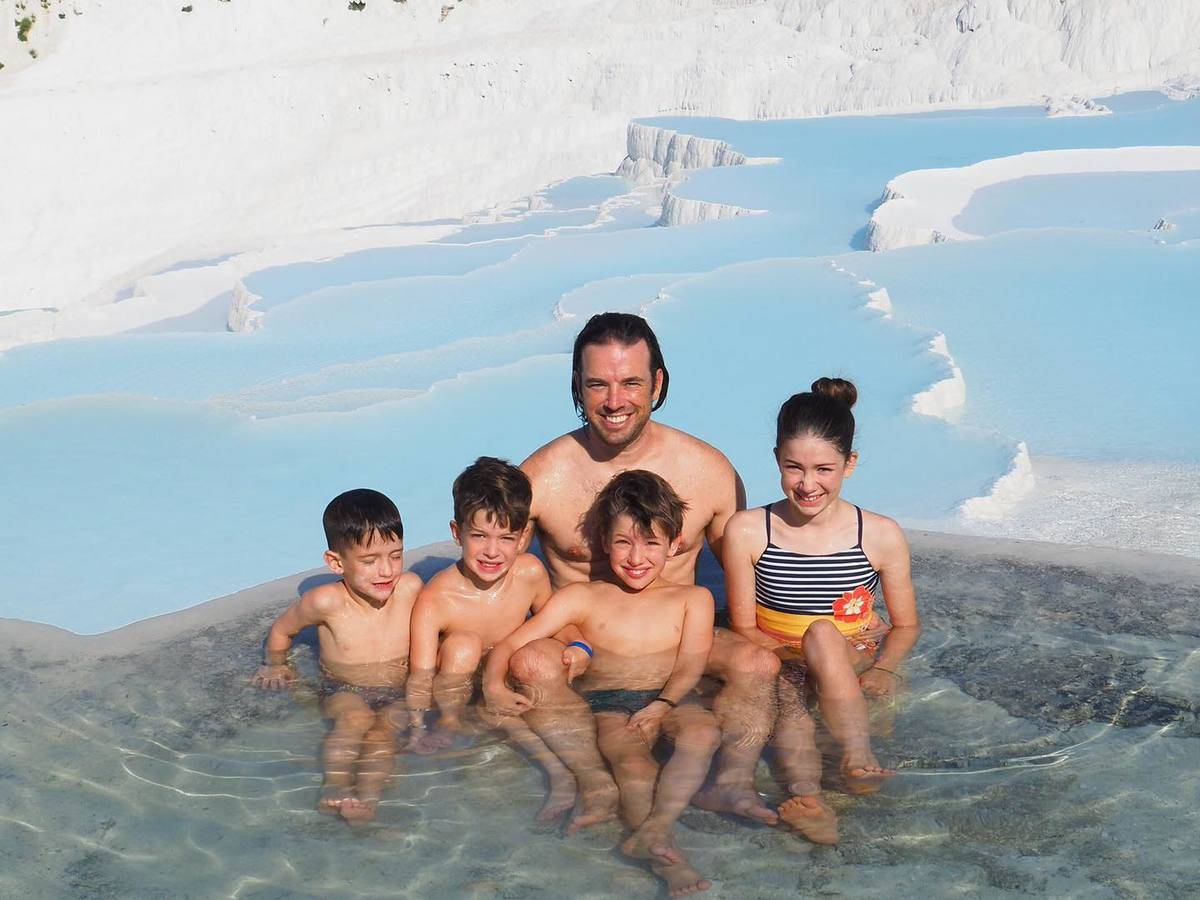 kids and dad in natural pool by glaciers