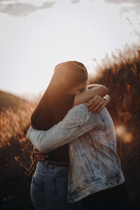man and woman hug in field