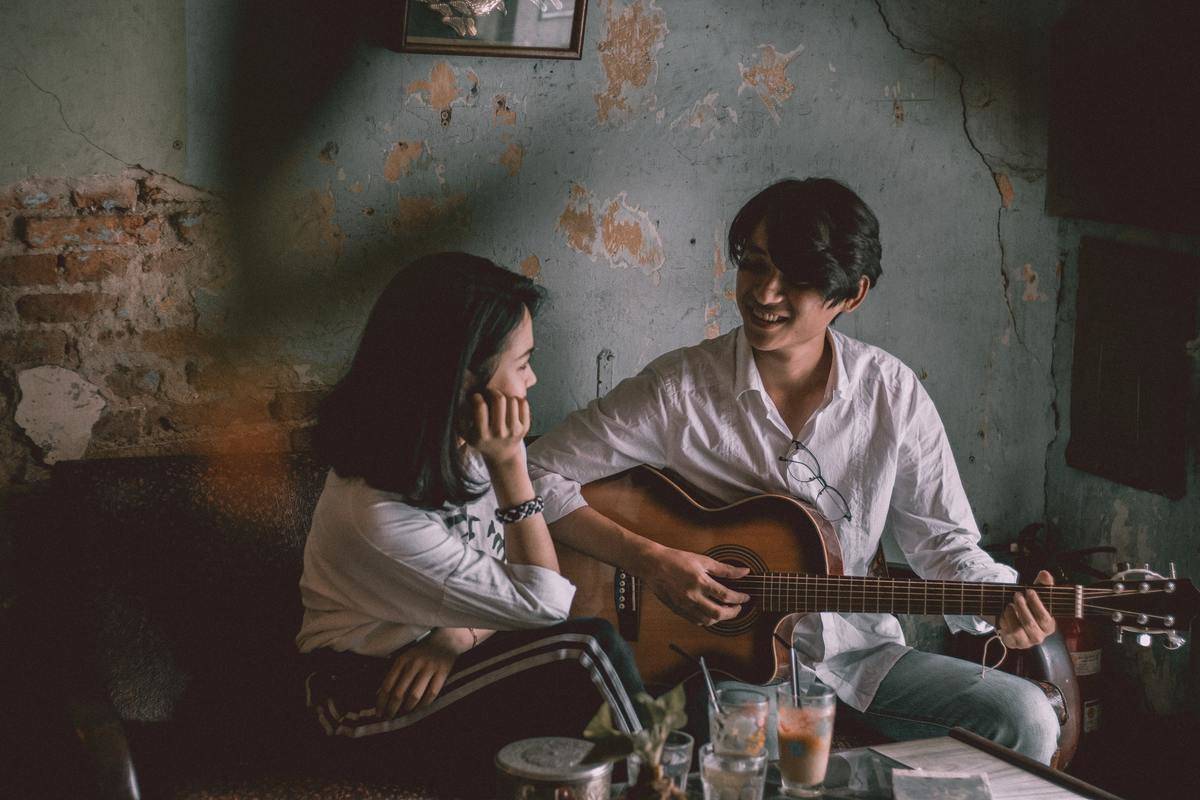 man-playing-guitar-with-girl watching him