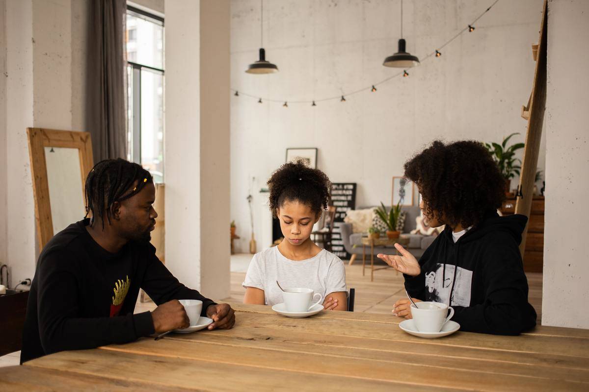 black-parents-lecturing-upset-daughter-at-table