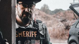 sheriff in uniform by car 