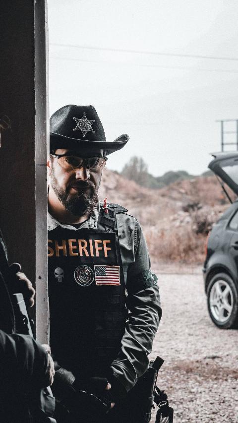 sheriff in uniform by car 