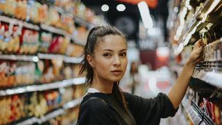 woman grocery shopping looking at the camera