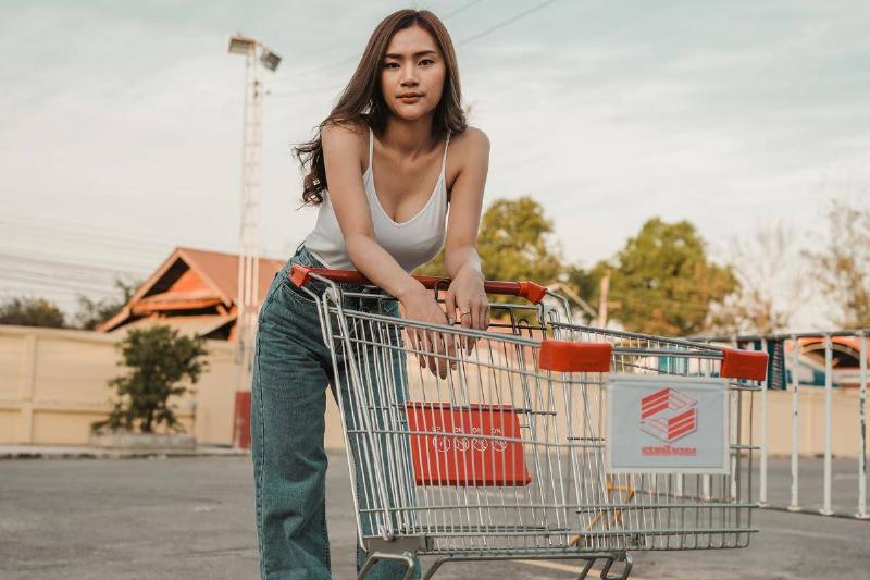 woman posing with grocery cart in parking lot
