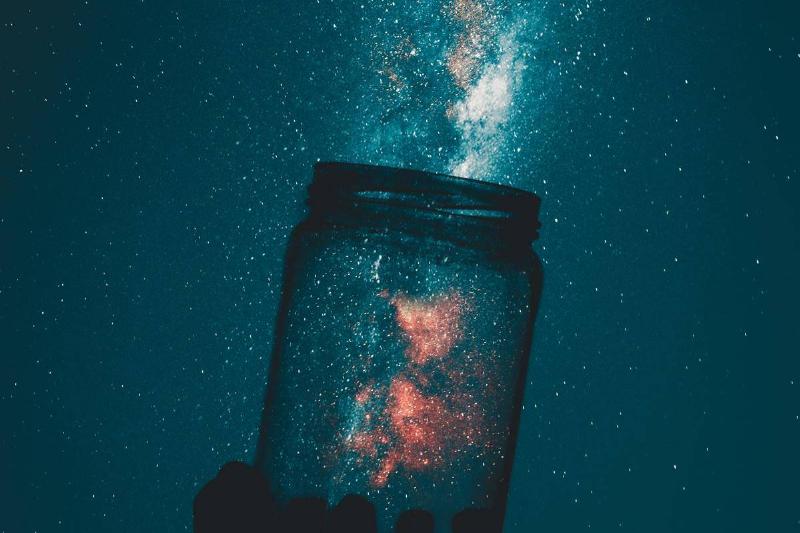 reative-photo-of-person-holding-glass-mason-jar-under-a-starry-sky