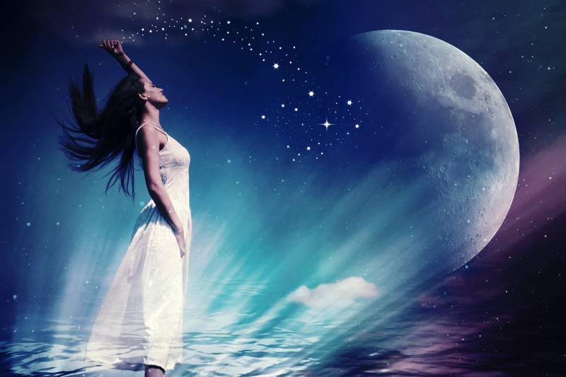 Woman standing on water under moonlight
