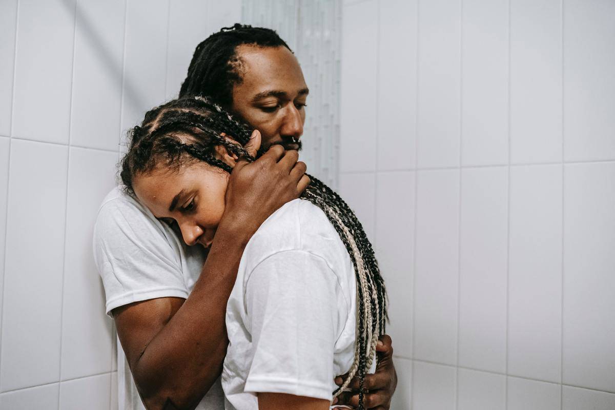 wistful-black-couple-hugging-in-bathroom-