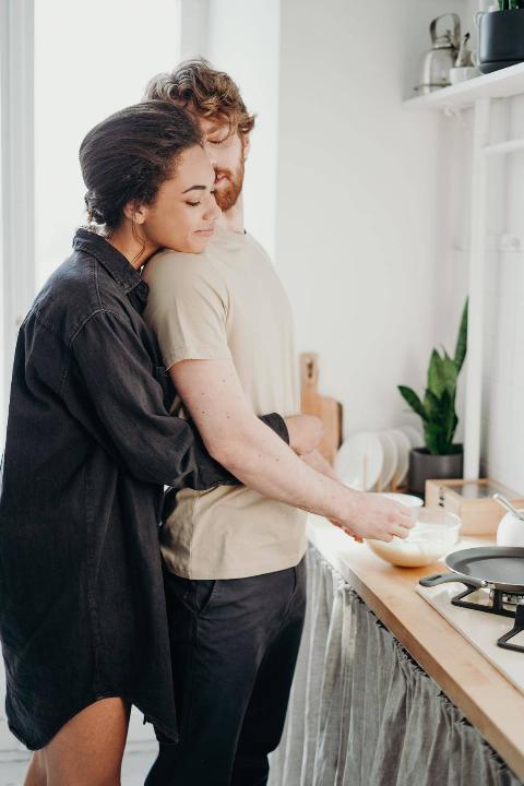photo-of-woman-hugging-her-man from behind while he cooks