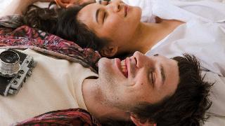 a-shot-of-a-couple-laying-on-a-bed-and-smiling-