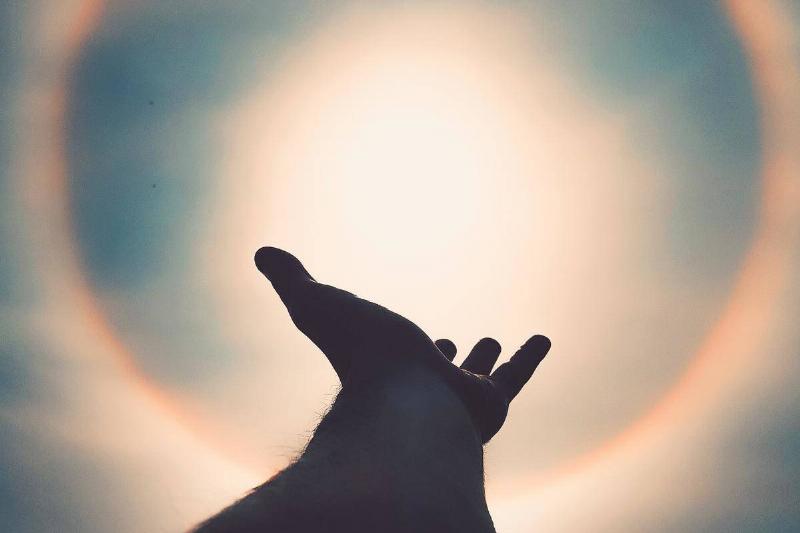 hand reaches out for light halo