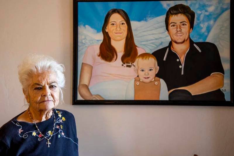 Donna Casasanta poses in front of a painting showing her late son, Harold Dean Clouse Jr., with Clouse's wife, Tina Gail Linn, and their daughter, Holly Marie Clouse, at Casasanta's Edgewater, Fla., home on Friday, Jan. 14, 2022.