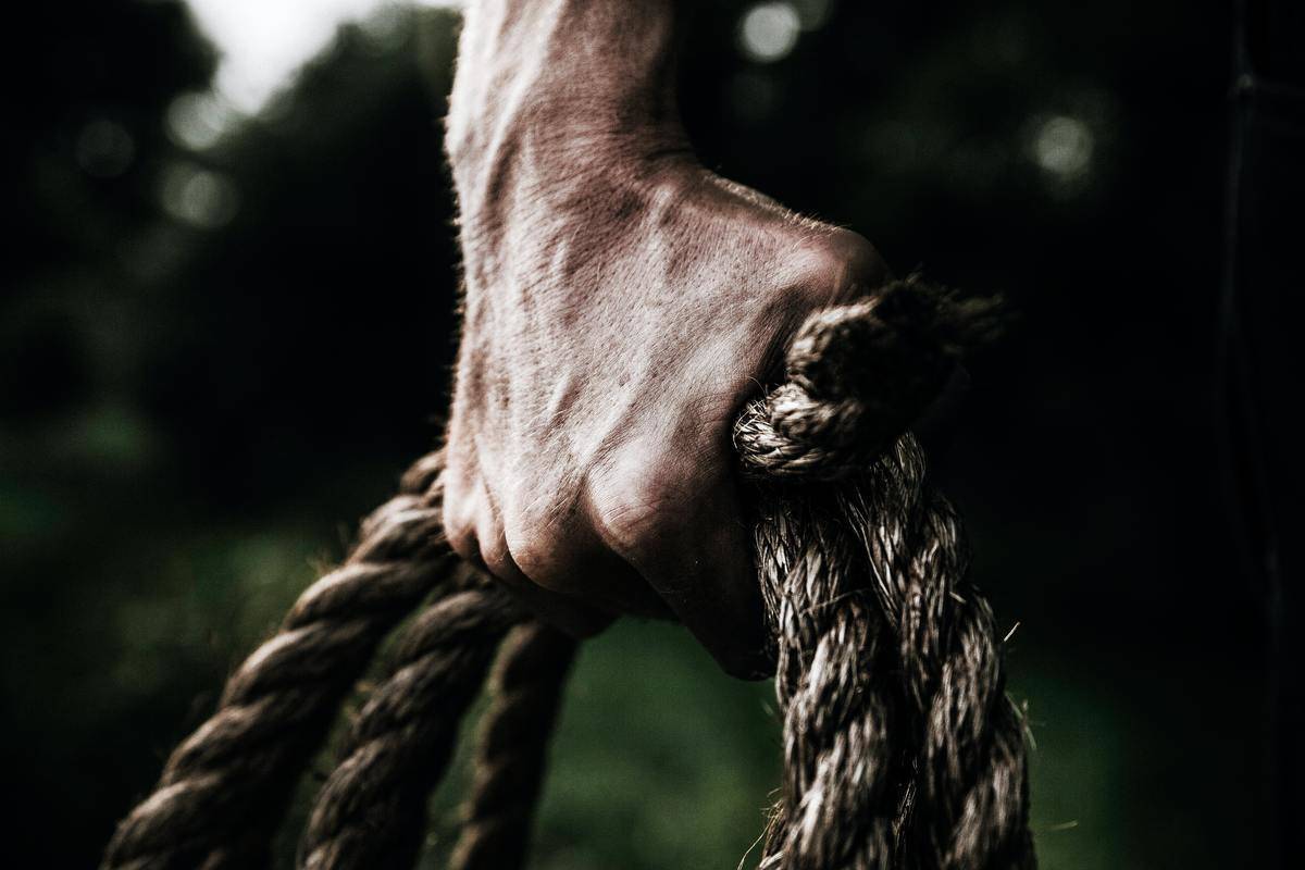 man's hand-holding-brown-rope