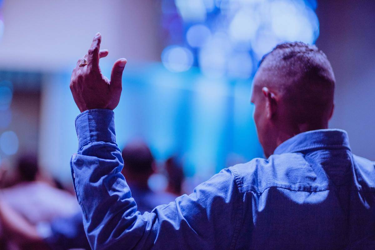 man-wearing-blue- shirt praying in church
