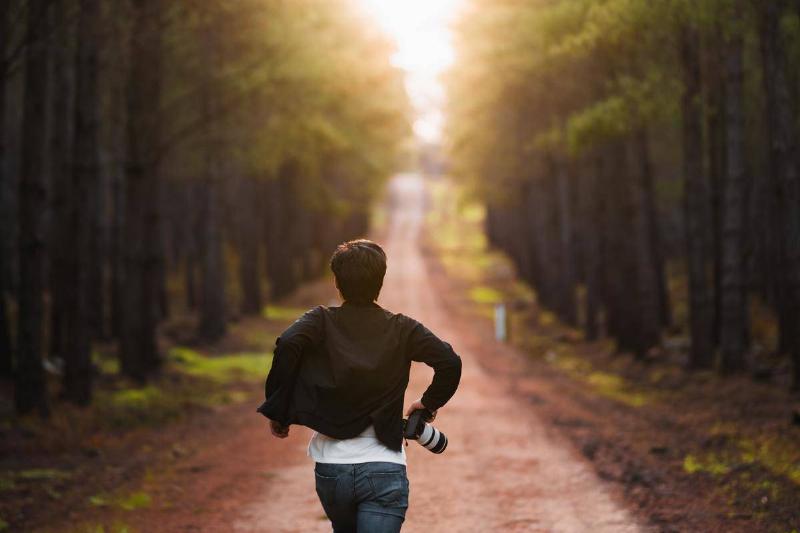 man running through path in a forest