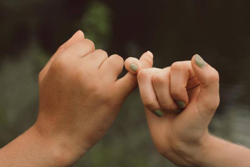 two hands pinky promise outdoors