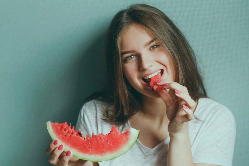 woman-wearing-white-shirt-eating-watermelon