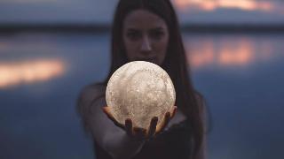 woman-holding-a-moon-shaped-lamp like the moon