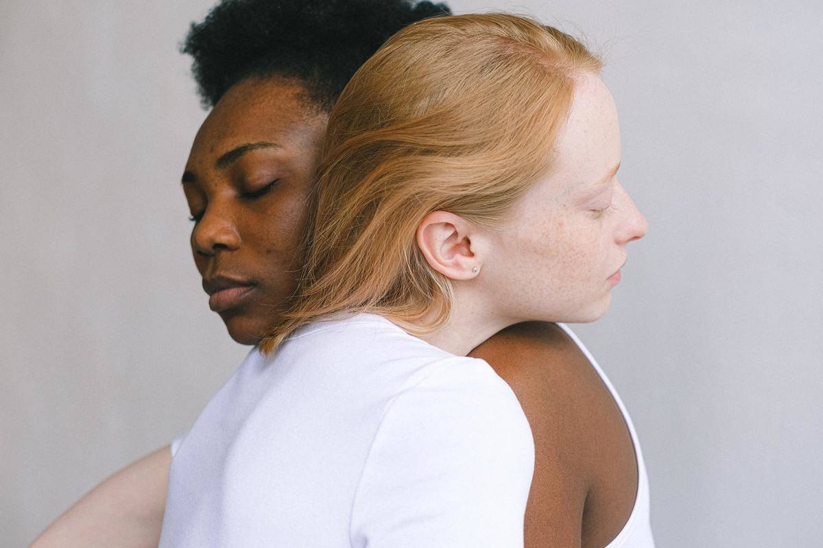 red headed woman and black woman-hugging-each-othe