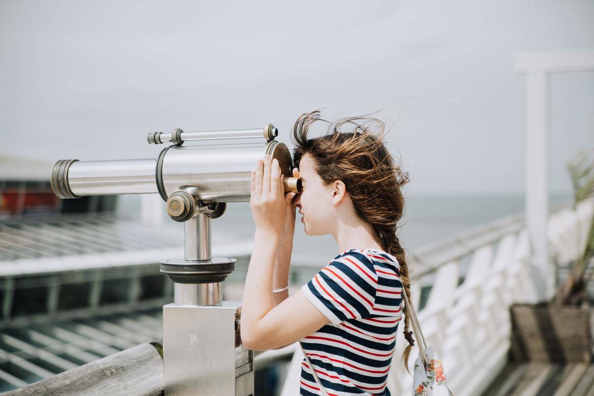 Girl Looking Through Telescope on bridge