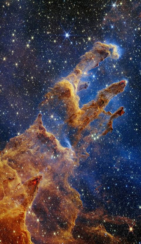 The Pillars of Creation are set off in a kaleidoscope of color in NASA's James Webb Space Telescope’s near-infrared-light view. The pillars look like arches and spires rising out of a desert landscape, but are filled with semi-transparent gas and dust, and ever changing. This is a region where young stars are forming – or have barely burst from their dusty cocoons as they continue to form.