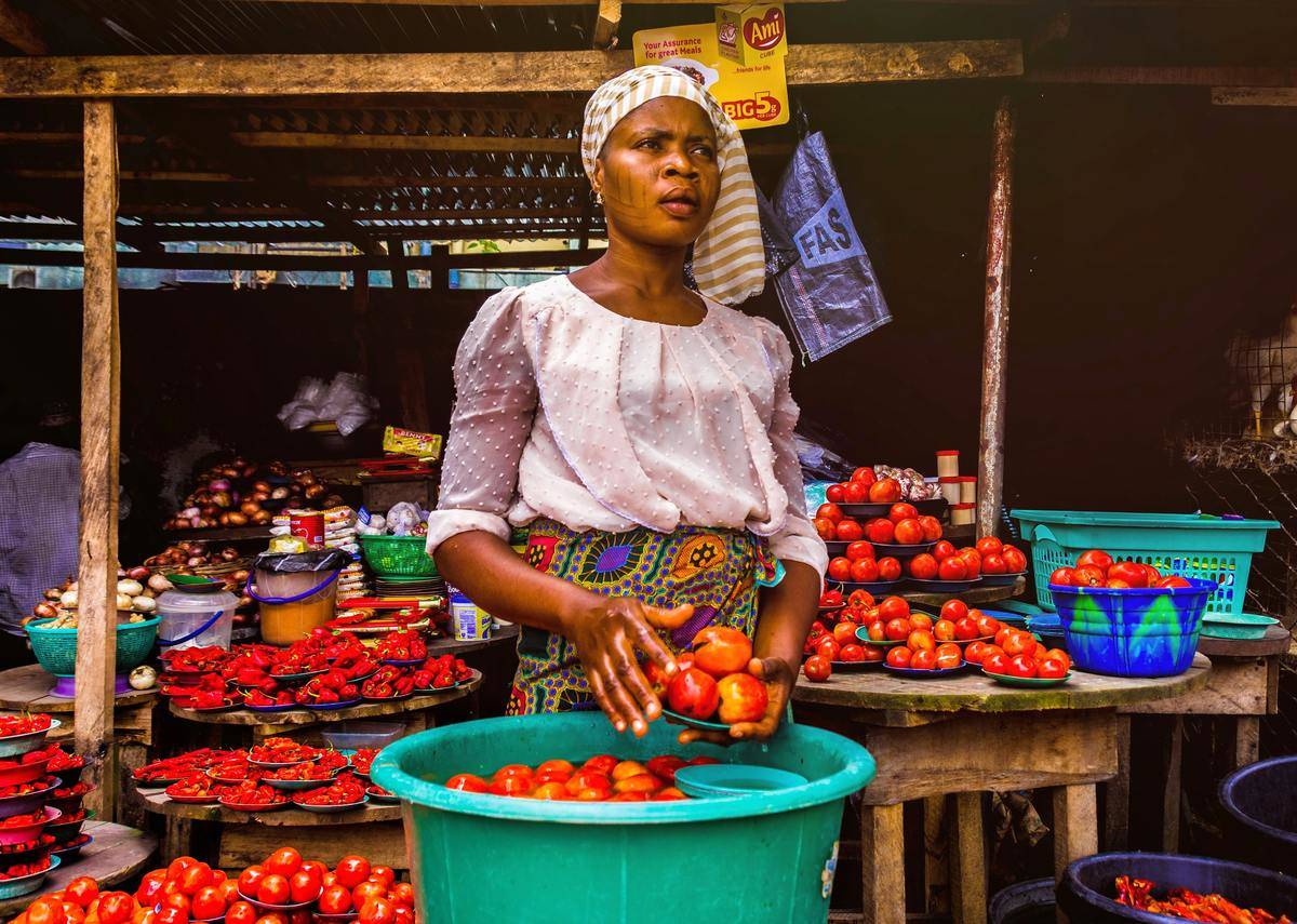 woman-holding-tomatoe in outdoor market