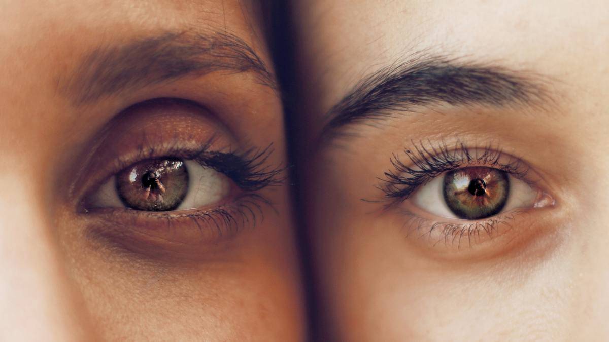 close up of green eyes of two faces