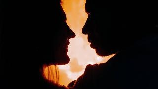 silhouette-of-couple-looking-at-each-other by the fire