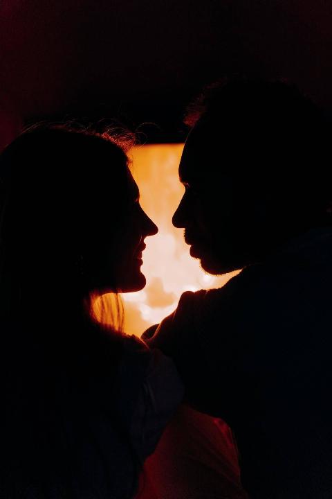 silhouette-of-couple-looking-at-each-other by the fire