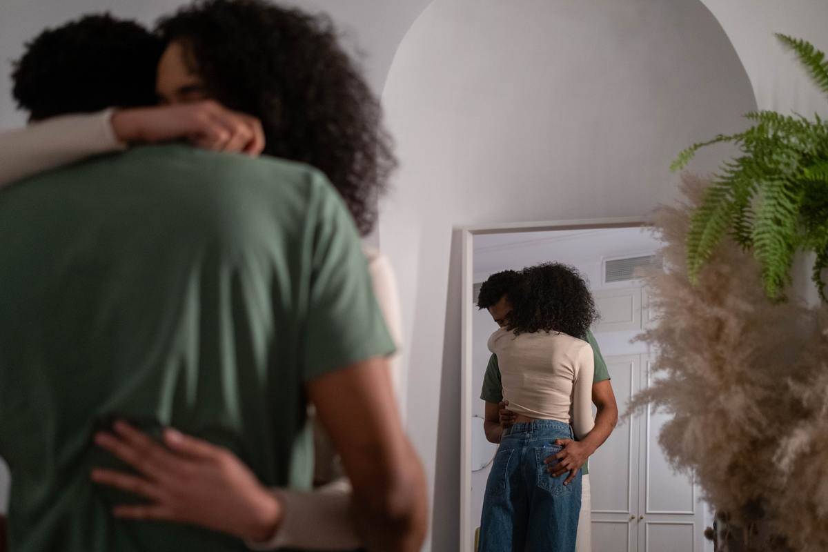 couple-hugging-each-other- with mirror behind them