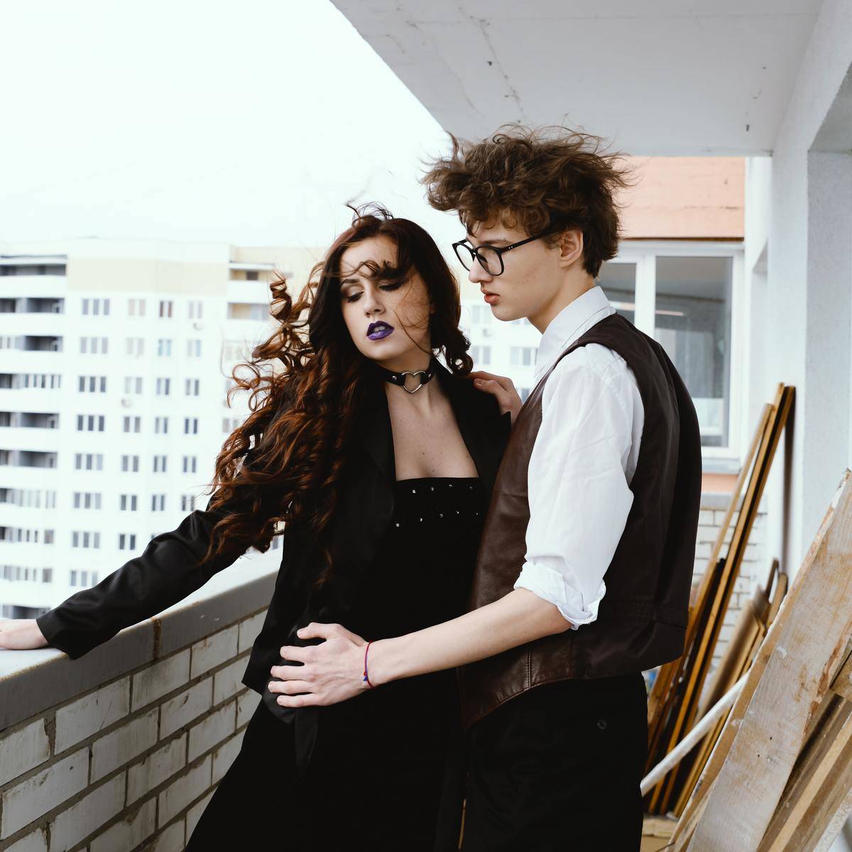 couple stands on balcony dressed up in black and white
