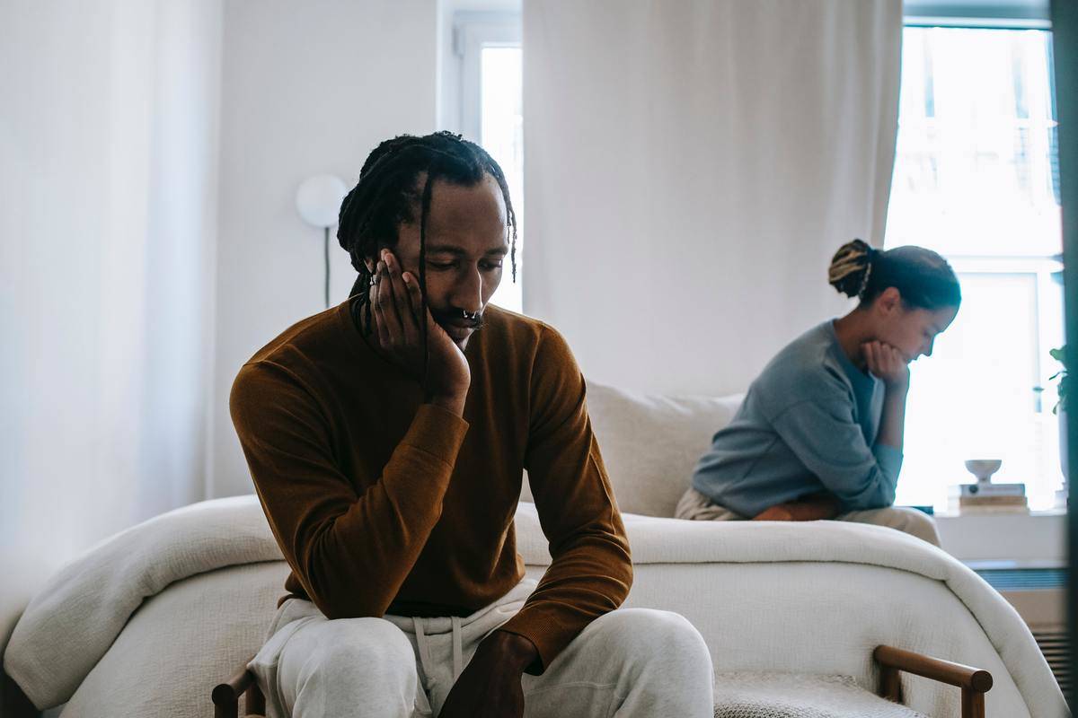 upset-black-couple-sitting-apart-at-home